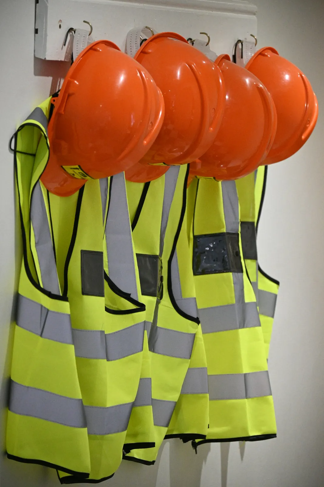 Orange hard hats and high visibility vests hanging ready for the crew